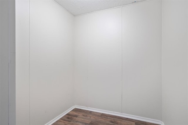 empty room with a textured ceiling and dark wood-type flooring