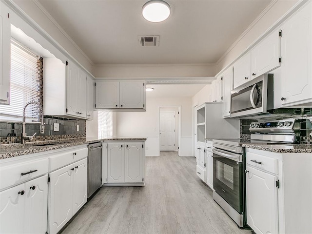 kitchen featuring stainless steel appliances, white cabinetry, a wealth of natural light, and sink