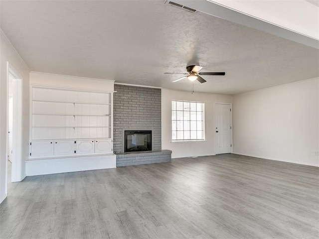 unfurnished living room with light hardwood / wood-style floors, a brick fireplace, and ceiling fan