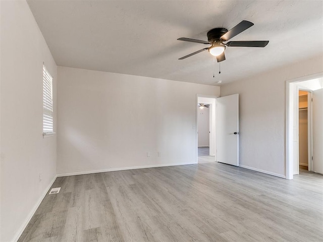 empty room featuring ceiling fan and light hardwood / wood-style flooring