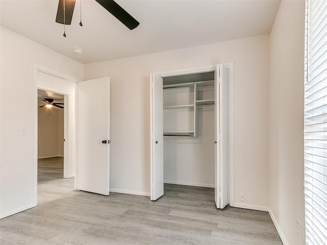 unfurnished bedroom featuring ceiling fan, a closet, and light wood-type flooring