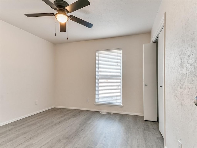 empty room featuring ceiling fan and light hardwood / wood-style floors