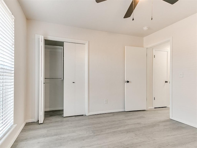 unfurnished bedroom featuring ceiling fan, a closet, and light wood-type flooring