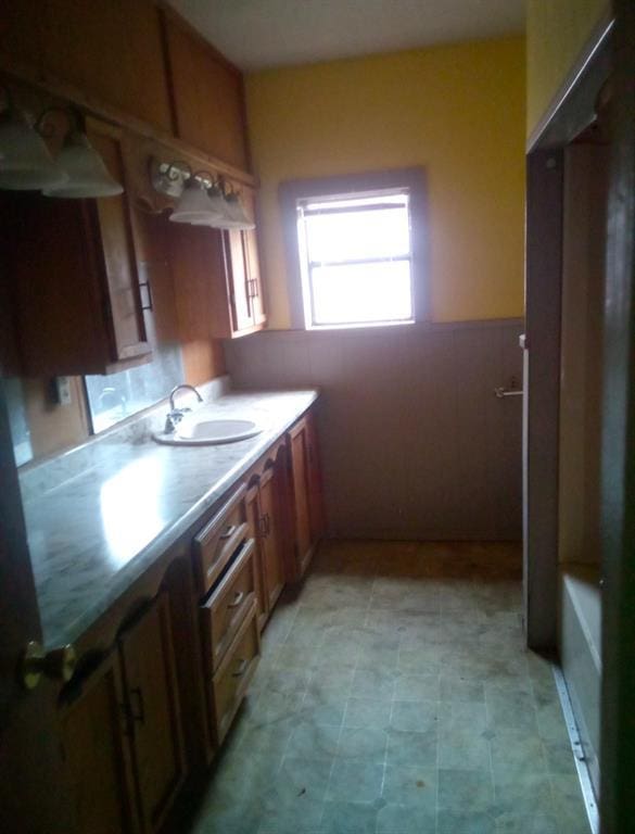 bathroom with sink and tile walls