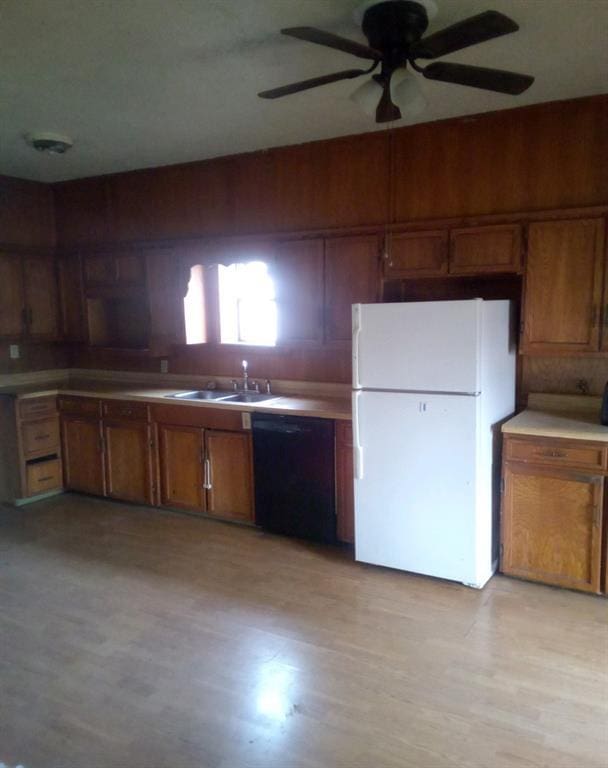 kitchen featuring dishwasher, white fridge, light hardwood / wood-style floors, and sink