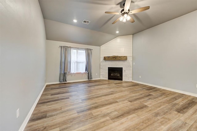 unfurnished living room with wood-type flooring, a fireplace, ceiling fan, and vaulted ceiling