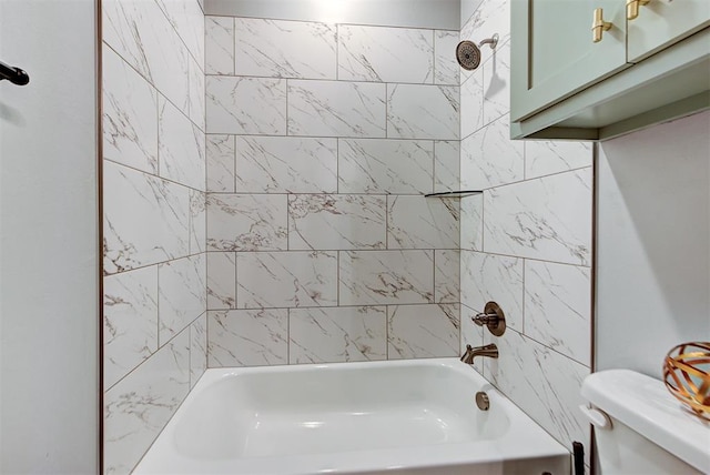 bathroom with tiled shower / bath combo and toilet