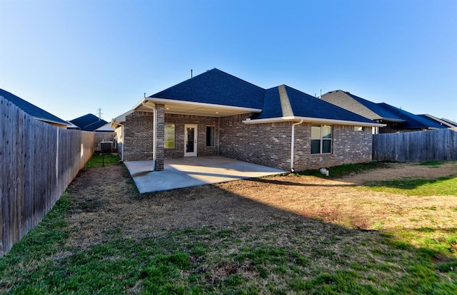 rear view of house with a yard, central AC, and a patio area