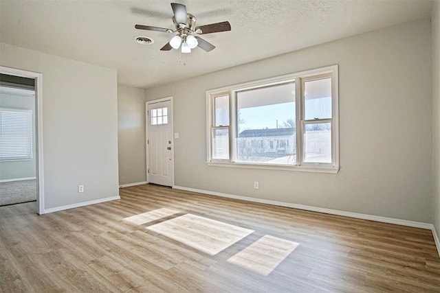 foyer with ceiling fan, light wood-type flooring, and a textured ceiling