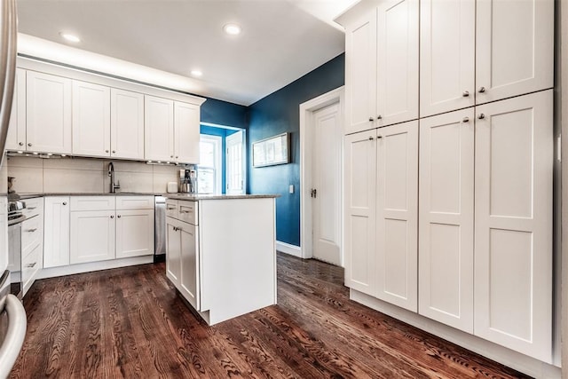 kitchen featuring sink, white cabinetry, tasteful backsplash, dark hardwood / wood-style floors, and a kitchen island