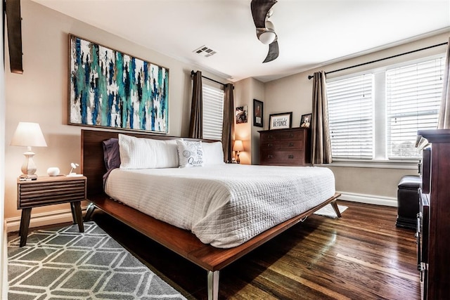 bedroom with dark hardwood / wood-style flooring and ceiling fan