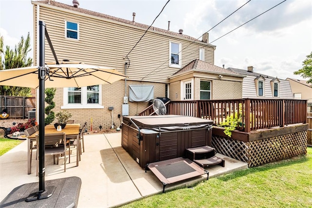 back of house featuring a hot tub, a wooden deck, and a patio area