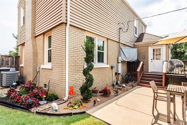 view of property exterior featuring central air condition unit and a patio