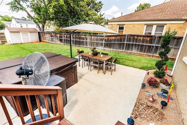 view of patio with a hot tub and a shed