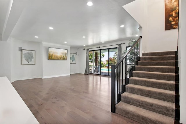 staircase featuring recessed lighting, wood finished floors, and baseboards