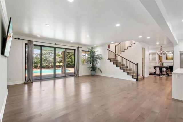 unfurnished living room featuring hardwood / wood-style flooring and a notable chandelier