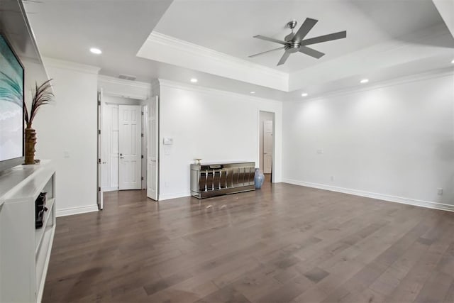 unfurnished living room with ceiling fan, a raised ceiling, ornamental molding, and dark wood-type flooring