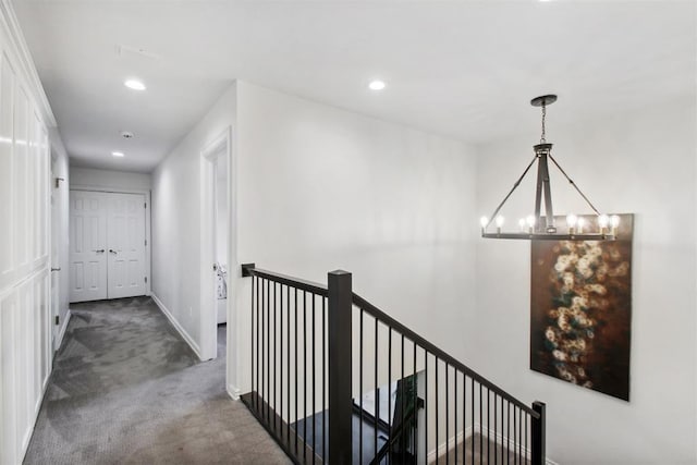 corridor with carpet, baseboards, recessed lighting, a notable chandelier, and an upstairs landing