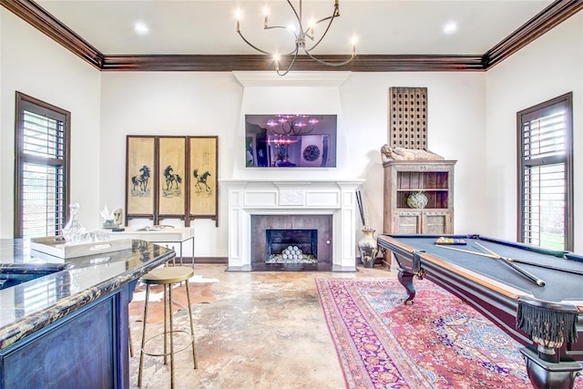 5801 Oak Tree Rd, Edmond, OK 73025 - recreation room with a chandelier, ornamental molding, plenty of natural light, a fireplace with flush hearth, and finished concrete flooring