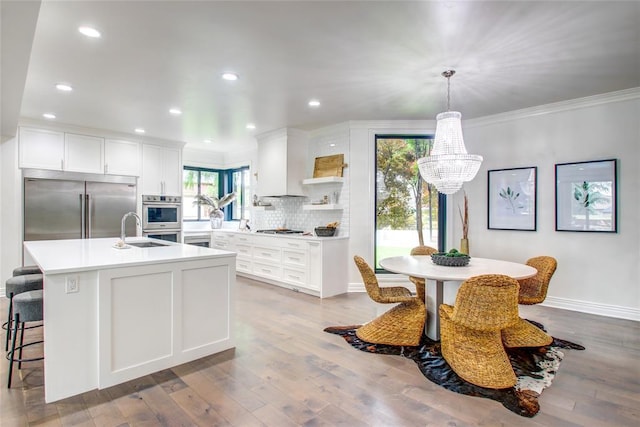 5801 Oak Tree Rd, Edmond, OK 73025 - kitchen featuring appliances with stainless steel finishes, a chandelier, crown molding, backsplash, and light countertops