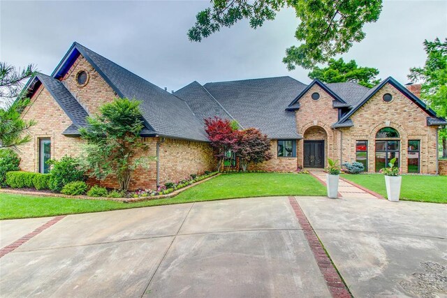 5801 Oak Tree Rd, Edmond, OK 73025 - view of front facade featuring brick siding, a shingled roof, and a front lawn