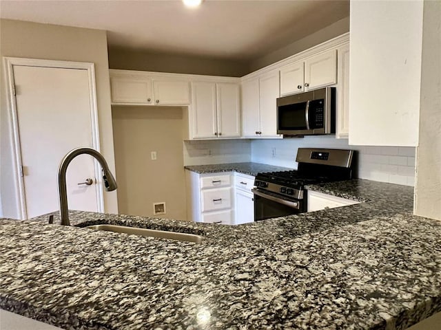 kitchen with white cabinets, sink, kitchen peninsula, and stainless steel appliances