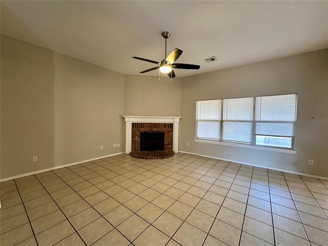 unfurnished living room featuring ceiling fan, light tile patterned floors, and a brick fireplace