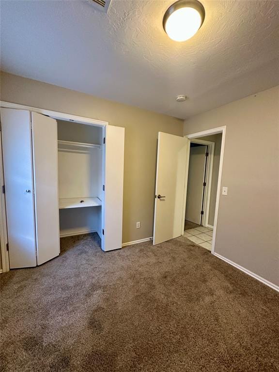 unfurnished bedroom with light colored carpet and a textured ceiling