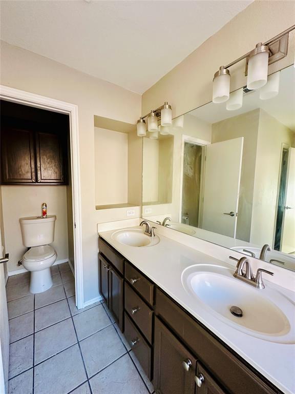 bathroom featuring tile patterned floors, vanity, and toilet