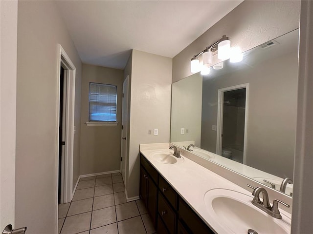 bathroom featuring tile patterned flooring, vanity, and toilet