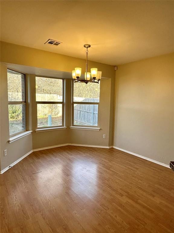 unfurnished room with dark hardwood / wood-style flooring and a notable chandelier