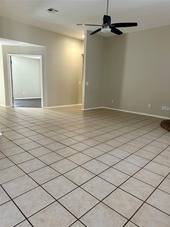 unfurnished room with ceiling fan and light tile patterned floors