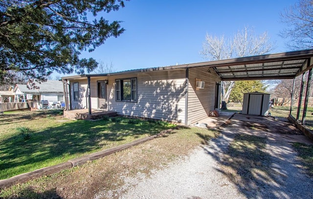 ranch-style home featuring a front yard, a shed, and a carport