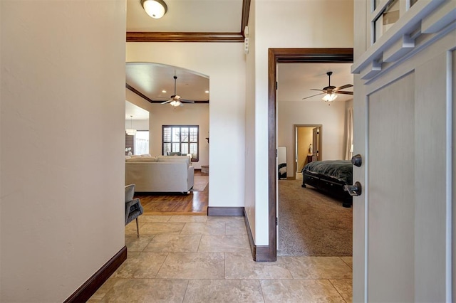 hallway featuring crown molding and light carpet