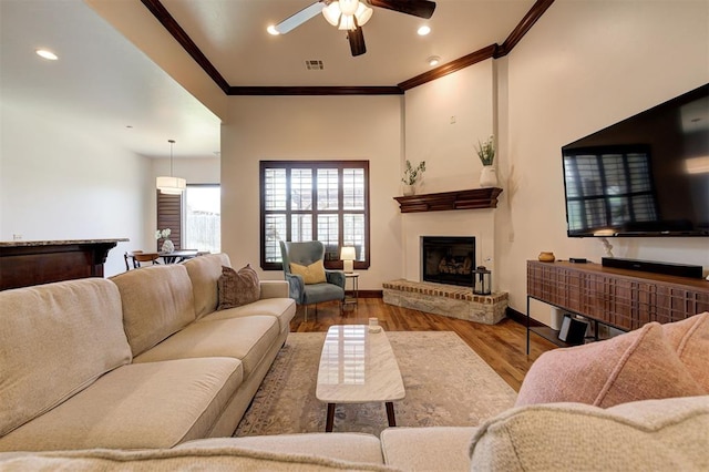 living room with hardwood / wood-style floors, ceiling fan, and ornamental molding