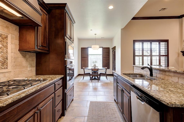 kitchen with decorative backsplash, stainless steel appliances, premium range hood, and sink