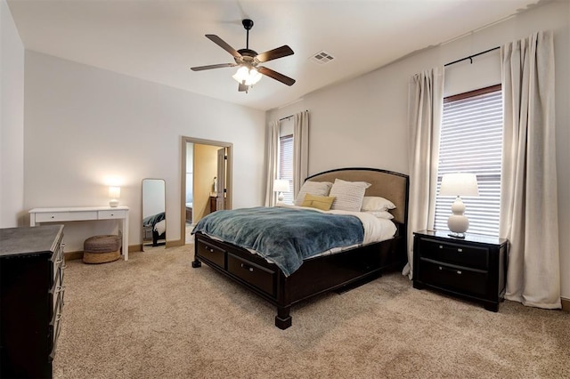 carpeted bedroom featuring multiple windows and ceiling fan