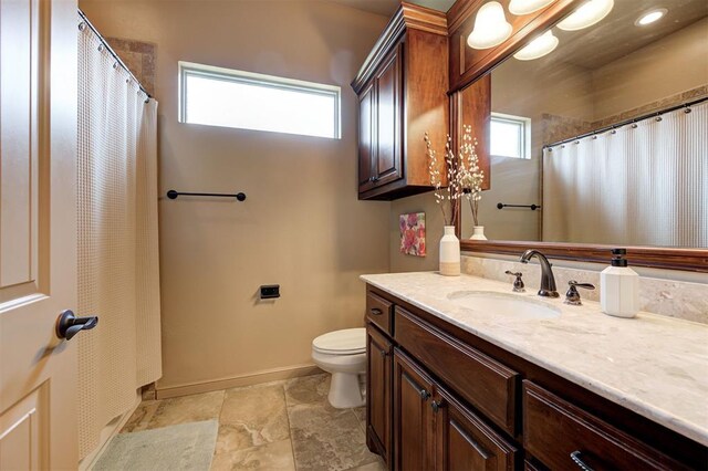 bathroom with a wealth of natural light, vanity, and toilet