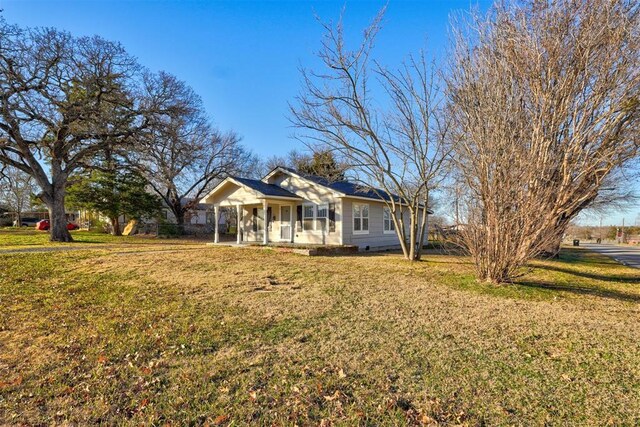 ranch-style home featuring a porch and a front lawn