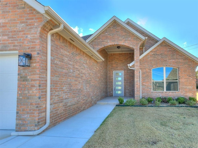 view of exterior entry with a yard