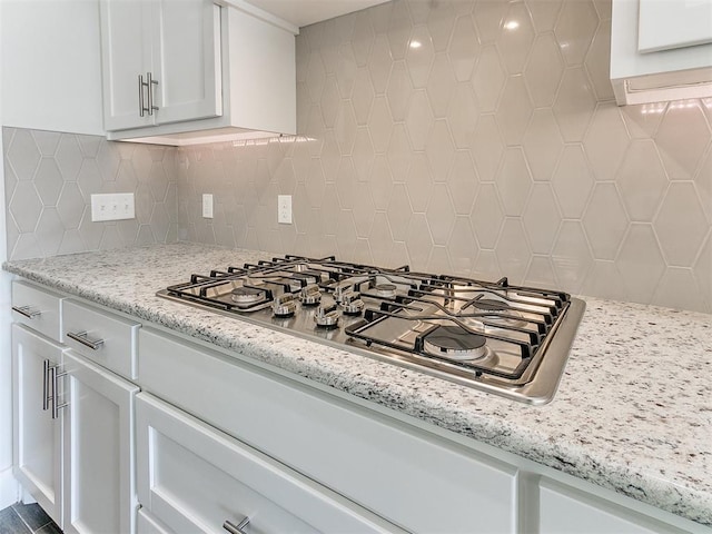 11400 NW 109th St, Yukon, OK 73099 - kitchen with stainless steel gas cooktop, white cabinetry, backsplash, and light stone countertops