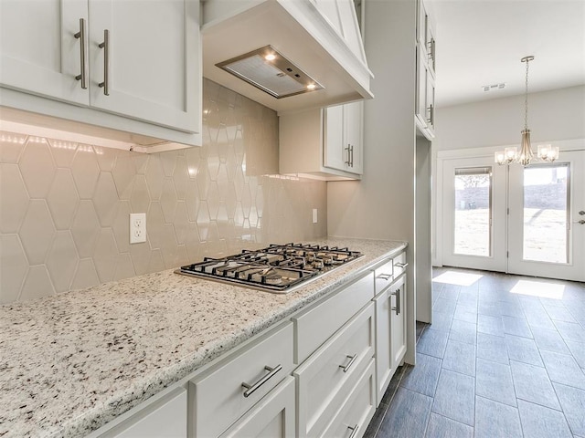 11400 NW 109th St, Yukon, OK 73099 - kitchen featuring stainless steel gas cooktop, custom range hood, backsplash, and white cabinets
