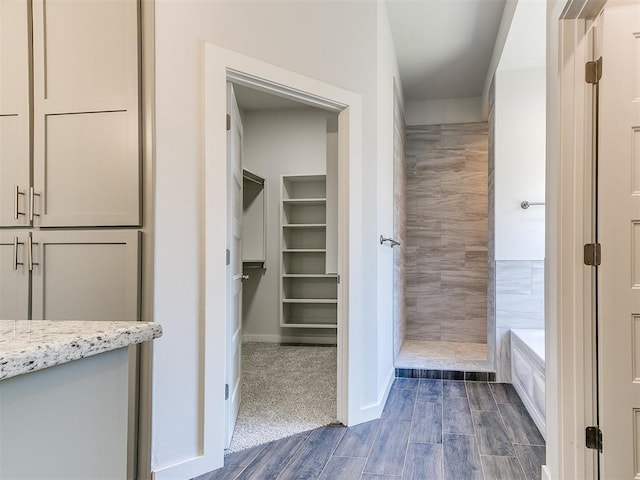 11400 NW 109th St, Yukon, OK 73099 - bathroom featuring a bath, a tile shower, wood finished floors, and a spacious closet