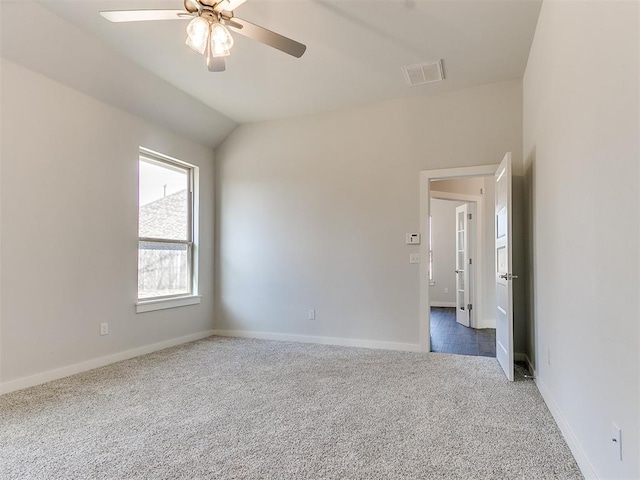 empty room featuring ceiling fan, dark carpet, and lofted ceiling