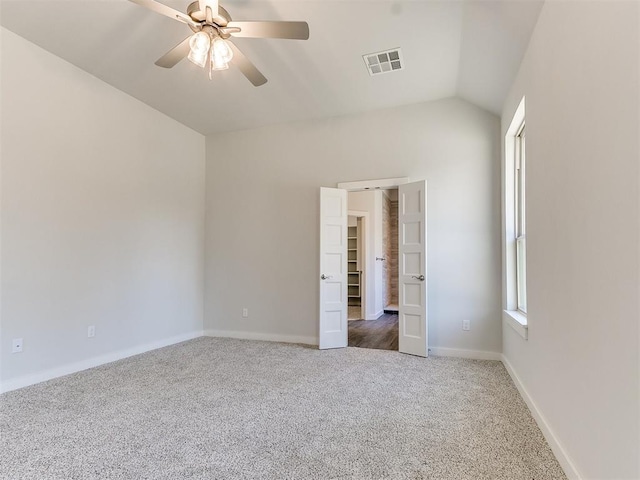 unfurnished room featuring ceiling fan, dark carpet, and lofted ceiling