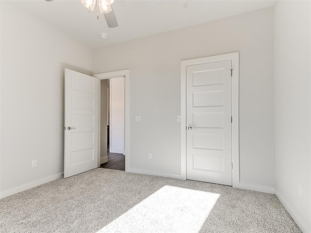 unfurnished bedroom featuring carpet, a closet, and ceiling fan