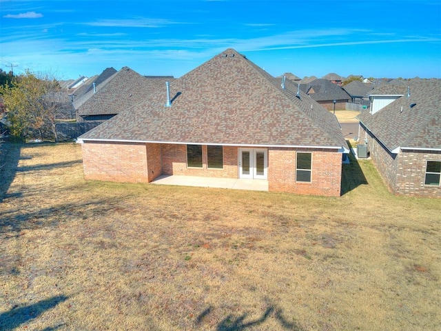 11400 NW 109th St, Yukon, OK 73099 - back of property featuring a patio area, a yard, french doors, a shingled roof, and brick siding