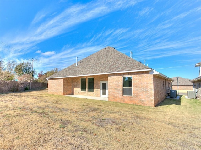 rear view of house featuring a lawn, a patio, and central AC unit