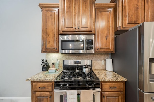 kitchen featuring backsplash, light stone countertops, and appliances with stainless steel finishes