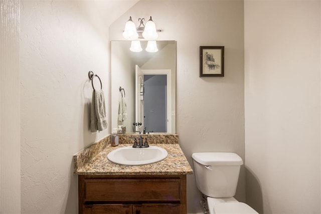 bathroom with vanity, toilet, and vaulted ceiling